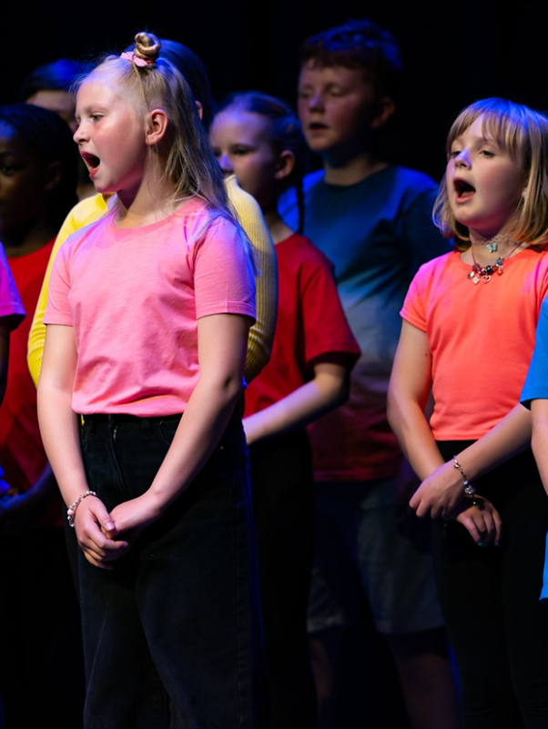Students in brightly coloured t-shirts  performing in Got to Sing event