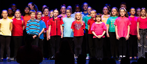Students in brightly coloured t-shirts  performing in Got to Sing event