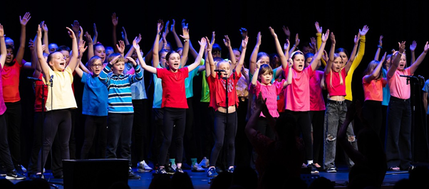 Students in brightly coloured t-shirts  performing in Got to Sing event