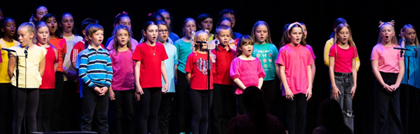 Students in brightly coloured t-shirts  performing in Got to Sing event