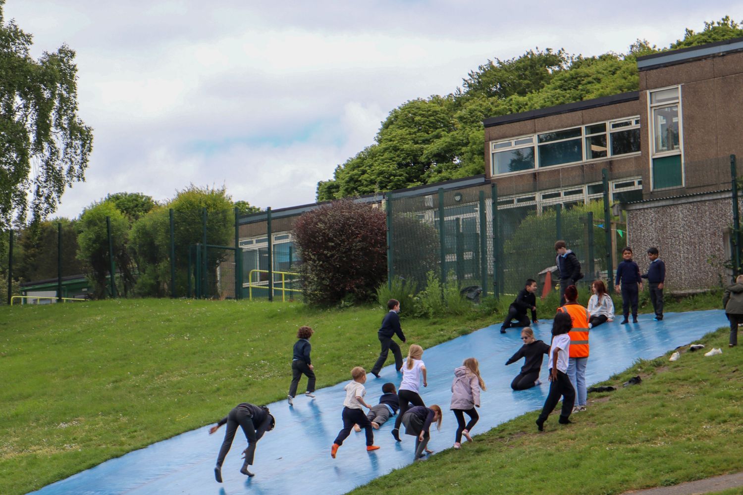 Students playing on the slip-and-slide that forms part of the OPAL equipment at the school